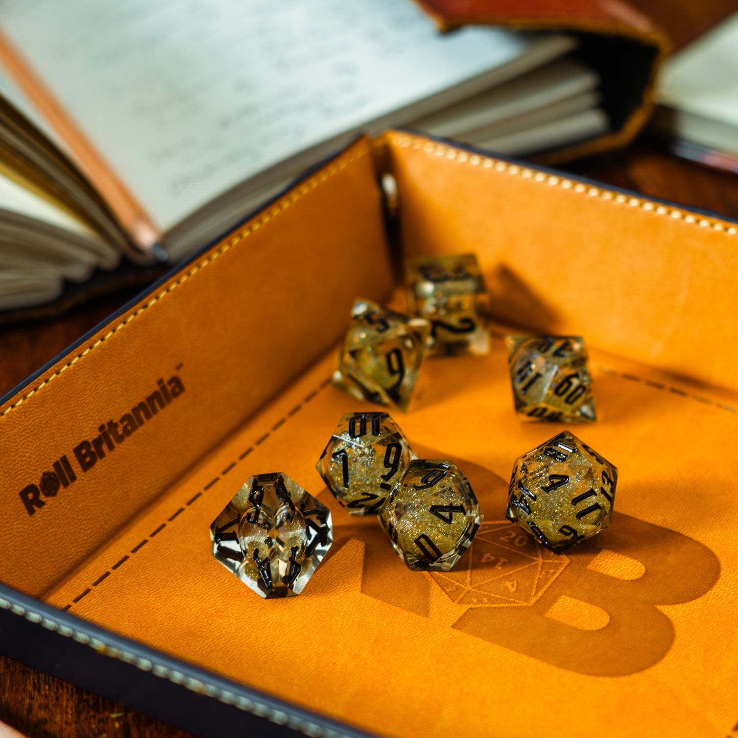 Roll Britannia Sharp Edge Resin Liquid Core Dungeons and Dragons Dice Set on branded leather dice tray