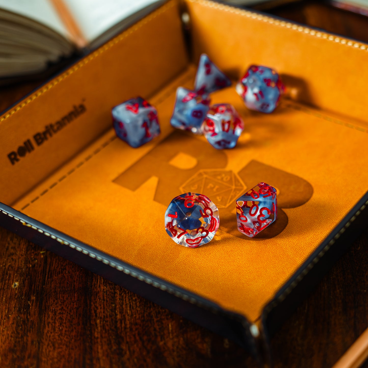 Roll Britannia Acrylic Dungeons and Dragons Dice Set with Red and Blue Ocean Aesthetic in branded leather dice tray